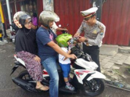  Kanit Lantas Polsek Pandaan Polres Pasuruan Memberikan Kado Buat Anak-Anak Yang Memakai Helm,