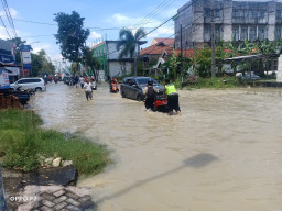 Jalan Terendam Banjir, Anggota Polsek dan Koramil Benjeng Bantu Dorong Motor Warga yang Mogok