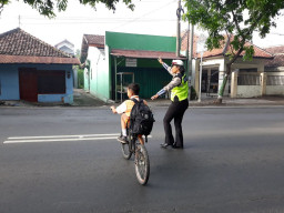 Sudah Biasa, Polantas Pasuruan Sebrangkan Anak Sekolah.