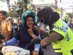 "Klik" Polwan Kaitkan Ikat Pengaman Helm Pada Pelajar