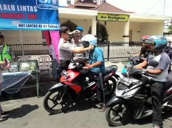 Polsek Wonokromo Bagi-Bagi Helm Saat Peringati Hari Satlantas