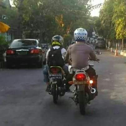 Anggota Polantas Dorong Motor Pelajar Agar Tidak Telat Sekolah.