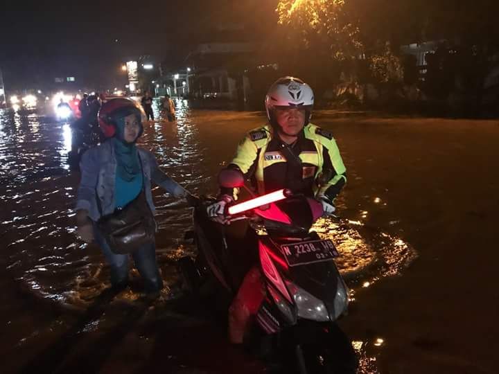 Sungai Pantura Pasuruan Meluap, Satlantas Bantu Pengguna Roda Dua.