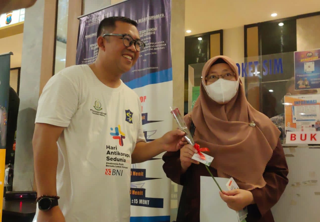 PERINGATI HARI ANTI KORUPSI SEDUNIA HAKORDIA, KEJARI TANJUNG PERAK BAGI BUNGA DAN STIKER DI JALAN TUNJUNGAN